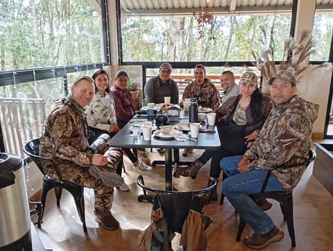 A group sharing a terrace with a forest view
