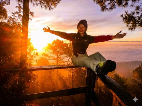 A person with open arms at sunset