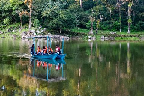 A boat on a lake surrounded by greenery