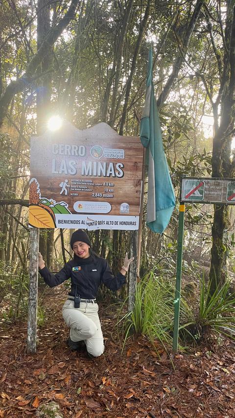 A hiker beside a forest sign