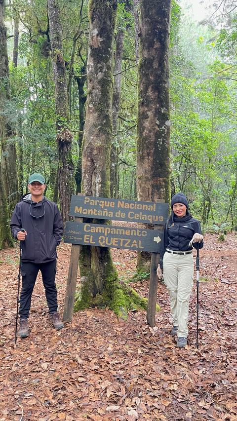 Hikers beside a forest sign