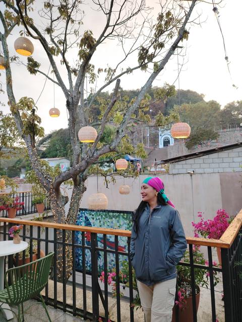 A person on a terrace with lanterns