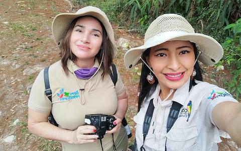Two people in hats taking a selfie in the forest
