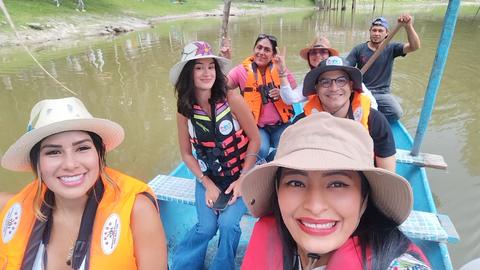 A group selfie in life jackets by the water