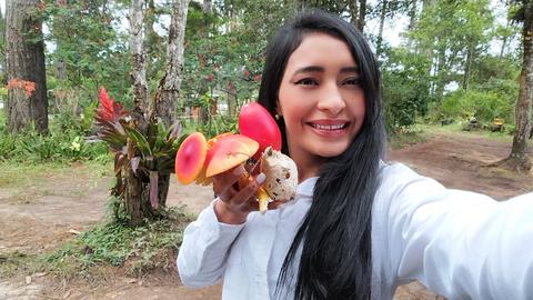 A guide taking a selfie beside red flowers