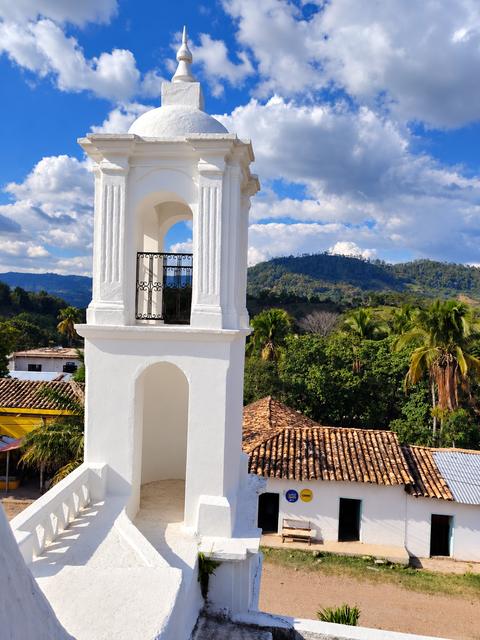A white tower with mountains behind