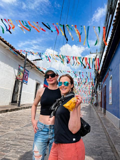 Two travellers on a street with bunting