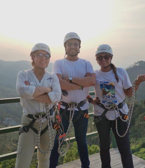 Three people with helmets and harnesses
