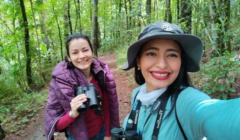 Two people taking a selfie among trees
