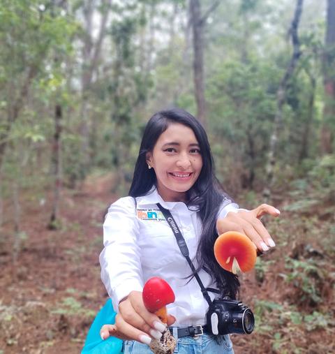 A guide holding coffee in the forest