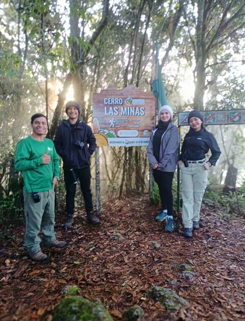 Hikers beside a sign in the forest
