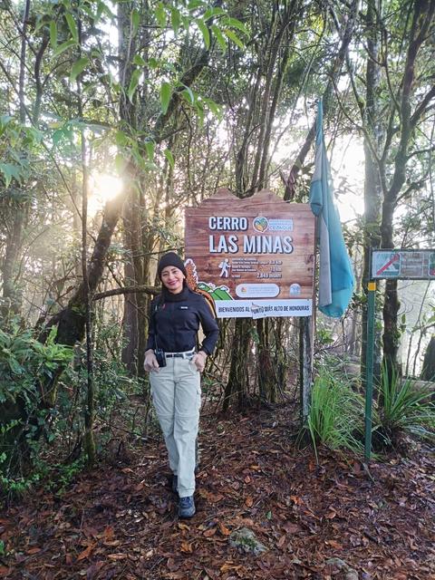 A hiker beside a forest sign