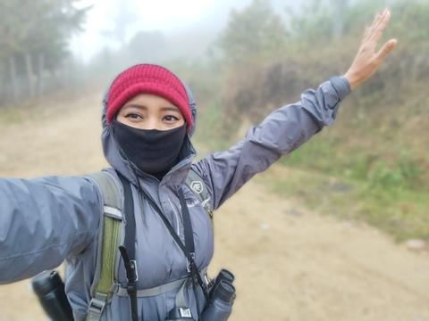 A hiker on a misty road