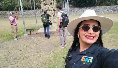 A guide in a hat taking a selfie on a trail