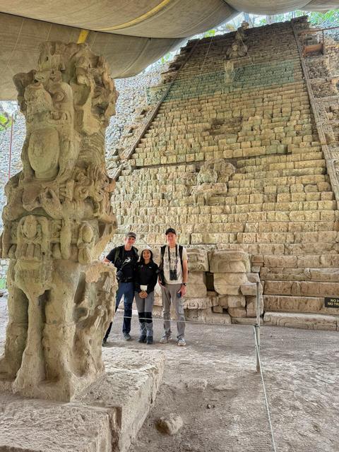 Visitors beside a stone sculpture and stairway